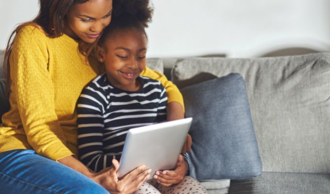 parent using tablet with child to homeschool