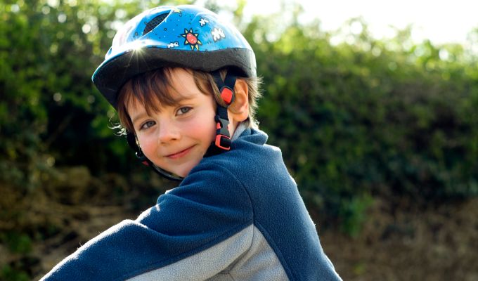 child wearing helmet riding balance bike